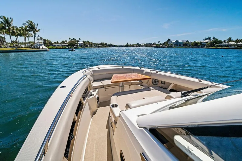 Slide: The Image of 2019 Boston Whaler 350 Realm cruising on a sunny day, featuring spacious deck and seating. - 3