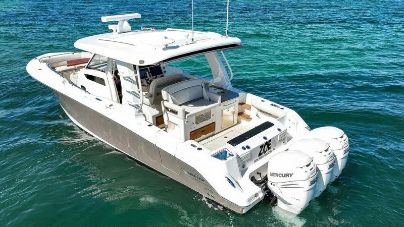 Slide: The Image of 2019 Boston Whaler 350 Realm boat on clear blue water, featuring triple Mercury engines. - 32