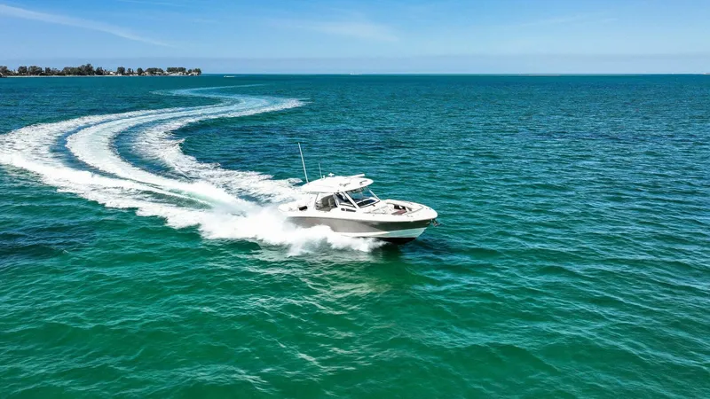 Slide: The Image of 2019 Boston Whaler 350 Realm cruising on open ocean under clear blue sky. - 36