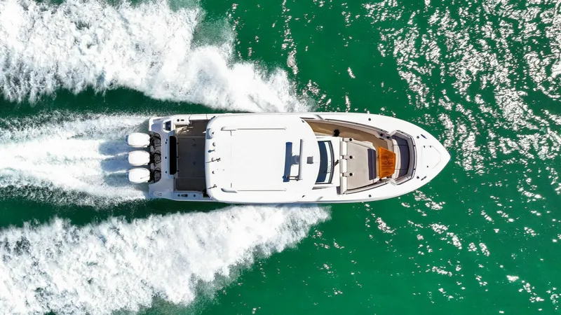 Slide: The Image of 2019 Boston Whaler 350 Realm cruising on vibrant turquoise waters, aerial view. - 40
