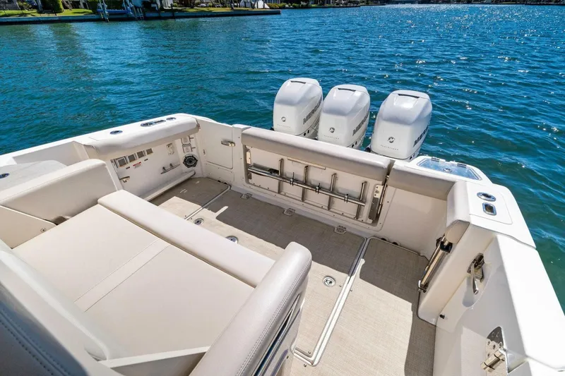 Slide: The Image of 2019 Boston Whaler 350 Realm boat interior with triple outboard engines on a sunny day. - 5