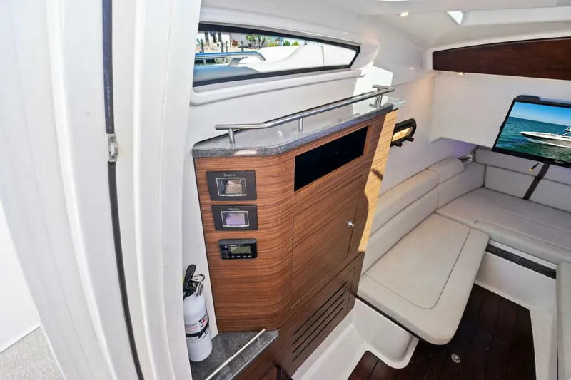 Slide: The Image of 2019 Boston Whaler 350 Realm cabin interior with seating and wooden cabinetry. - 7