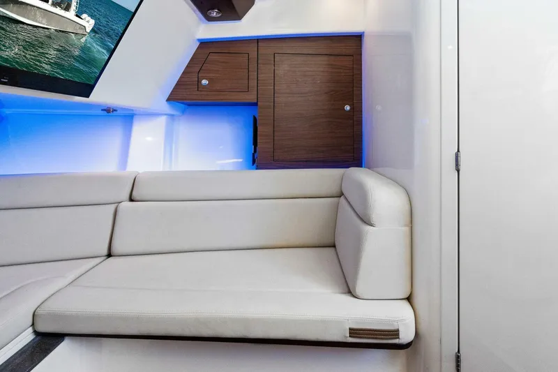 Slide: The Image of Interior of 2019 Boston Whaler 350 Realm with cushioned seating and wooden cabinets. - 8