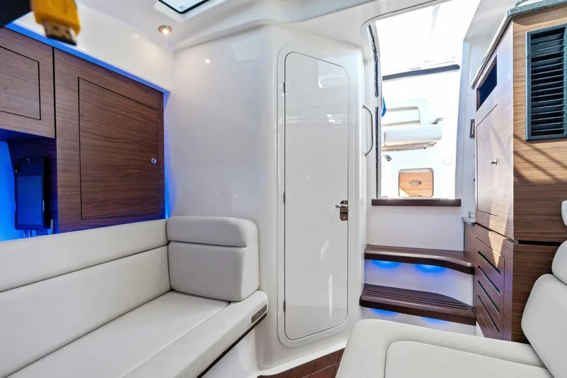 Slide: The Image of Interior of 2019 Boston Whaler 350 Realm, featuring modern seating and wooden cabinetry. - 9
