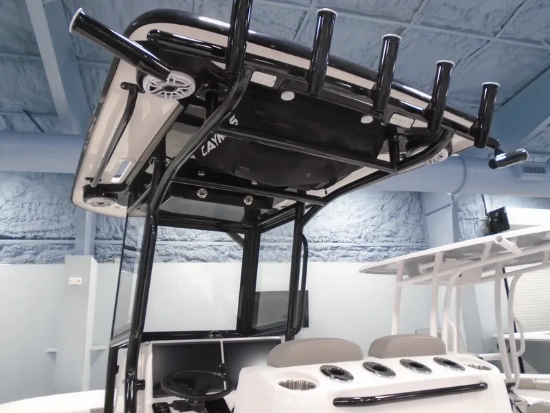 Slide: The Image of 2025 Caymas 281 HB boat with T-top and rod holders in showroom. - 26
