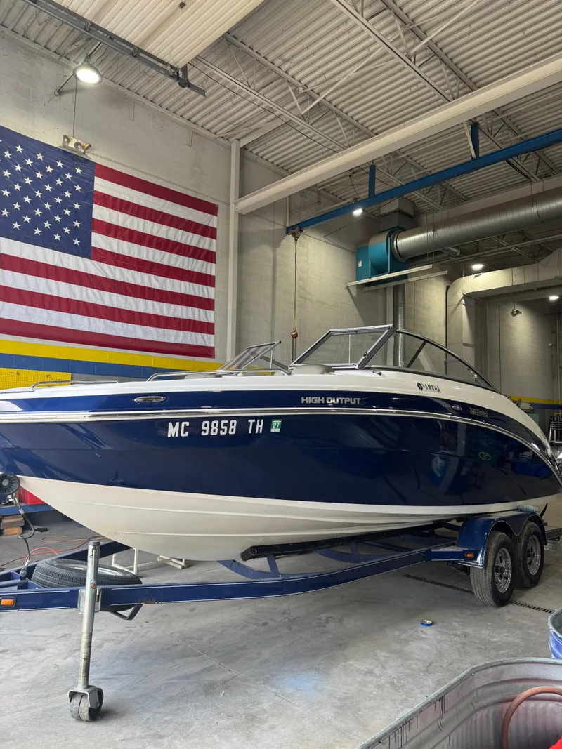 The Image of 2011 Yamaha Boats 242 Limited in garage, American flag backdrop. - 0