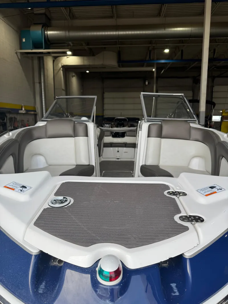 Slide: The Image of 2011 Yamaha Boats 242 Limited interior with seating and dashboard in a garage setting. - 3