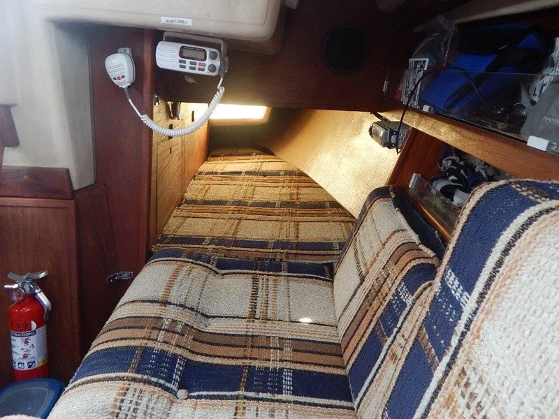Slide: The Image of Interior of 1983 Newport 28 Sloop with plaid upholstery and marine radio. - 13