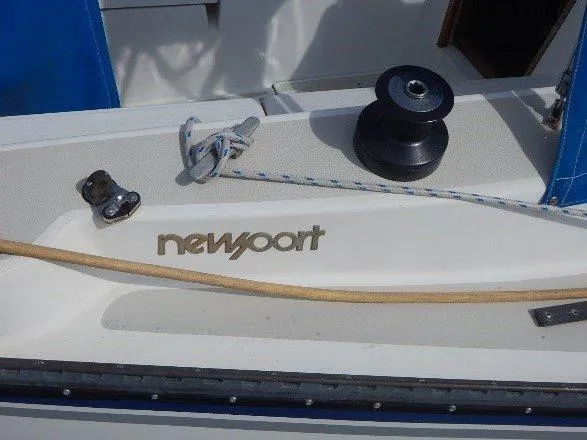 Slide: The Image of 1983 Newport 28 Sloop deck with winch, rope, and logo. - 16