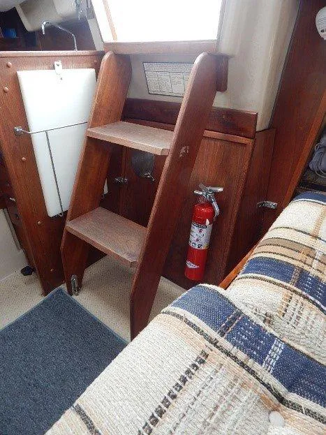 Slide: The Image of Interior of 1983 Newport 28 Sloop with wooden steps and fire extinguisher. - 17