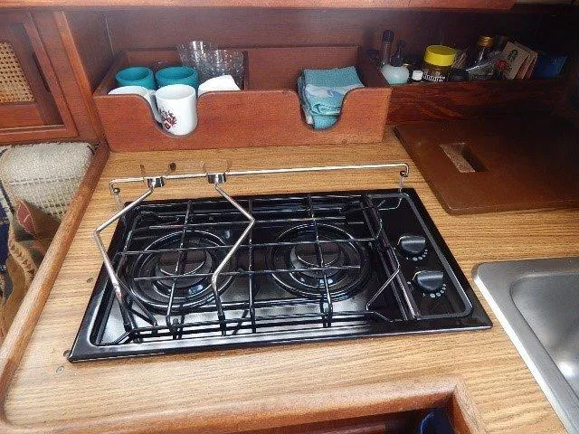 Slide: The Image of Compact galley kitchen in 1983 Newport 28 Sloop with stove and storage shelves. - 19