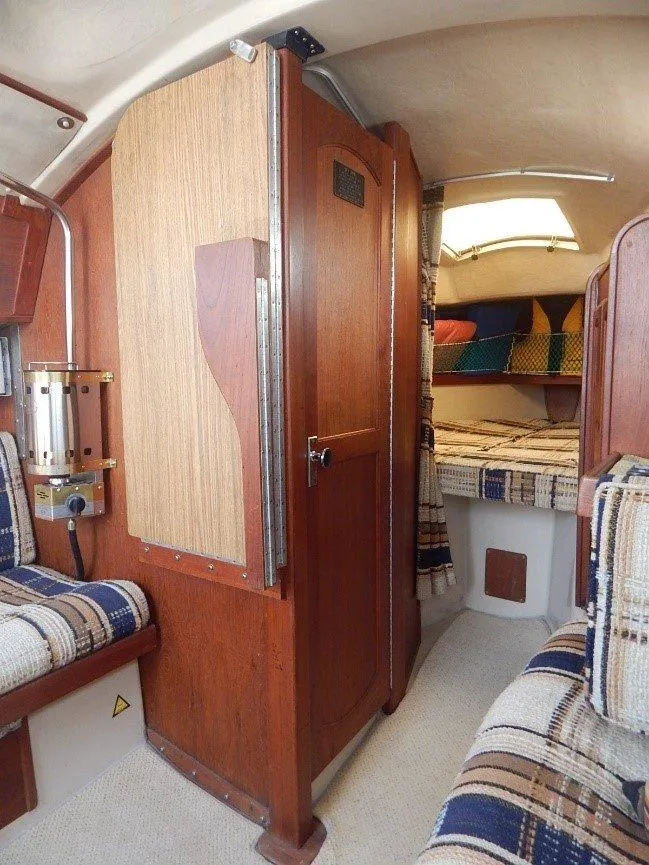 Slide: The Image of Interior of a 1983 Newport 28 Sloop sailboat with cozy seating and wooden finishes. - 9