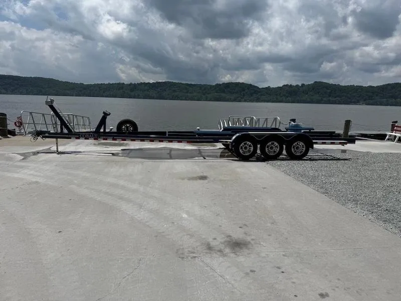 Slide: The Image of 2014 Cobalt boat trailer by a lake under cloudy skies. - 3