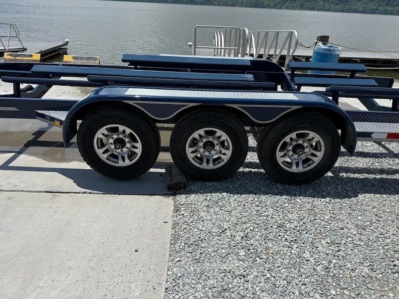 Slide: The Image of 2014 Cobalt boat trailer with triple axles near a lakeside dock. - 5