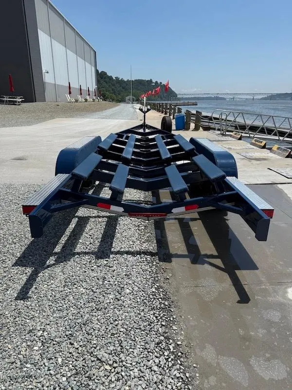 Slide: The Image of 2014 Cobalt boat trailer on gravel near waterfront, industrial building in background. - 7
