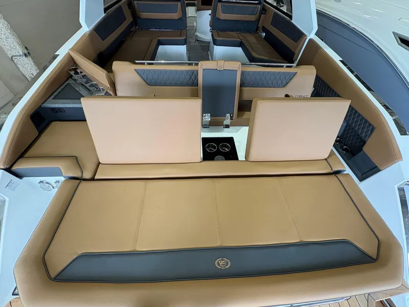 Slide: The Image of 2025 Cobalt R35 boat interior with tan and gray seating, featuring cup holders. - 2
