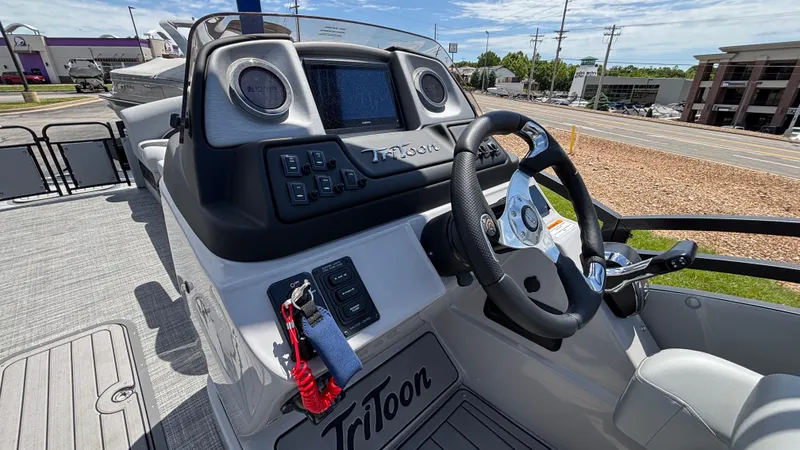 Slide: The Image of 2025 JC Neptoon 25TT Sport boat dashboard with steering wheel and control panel. - 16