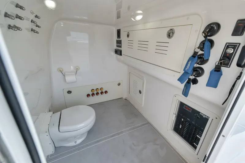 Slide: The Image of Interior of 2018 Invincible 40 Catamaran showing bathroom with toilet and control panels. - 24