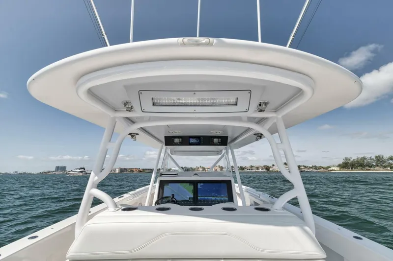 Slide: The Image of 2018 Invincible 40 Catamaran helm with navigation screens, ocean view, and clear sky. - 38