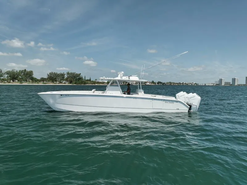 Slide: The Image of 2018 Invincible 40 Catamaran on calm waters near a coastal cityscape. - 4