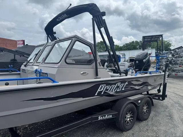Slide: The Image of 2023 SeaArk Pro Cat 240 boat with Suzuki engine on a trailer, under cloudy skies. - 13