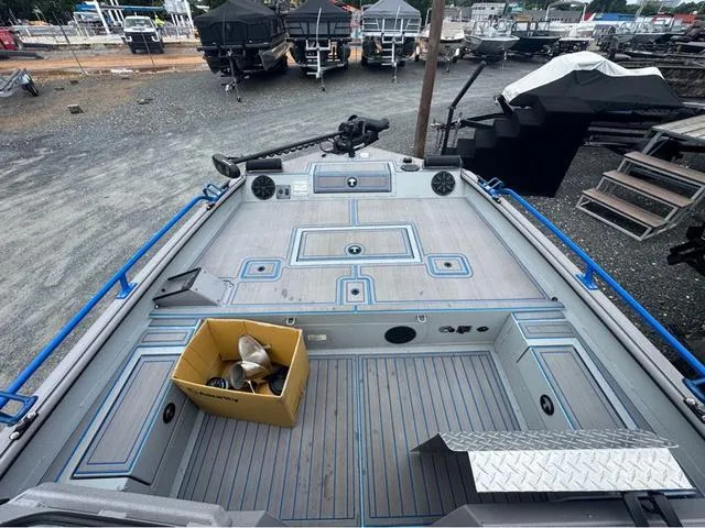 Slide: The Image of 2023 SeaArk Pro Cat 240 boat deck with storage and equipment, docked outdoors. - 15