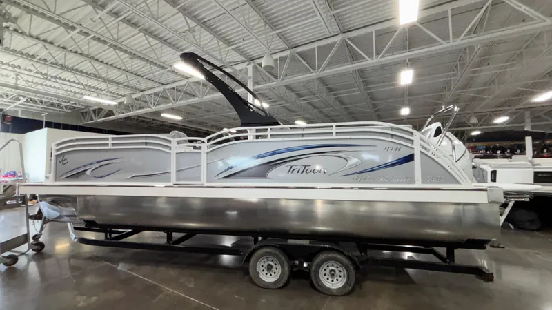 Slide: The Image of 2025 JC Neptoon 25TT Sport pontoon boat on trailer in indoor showroom. - 1