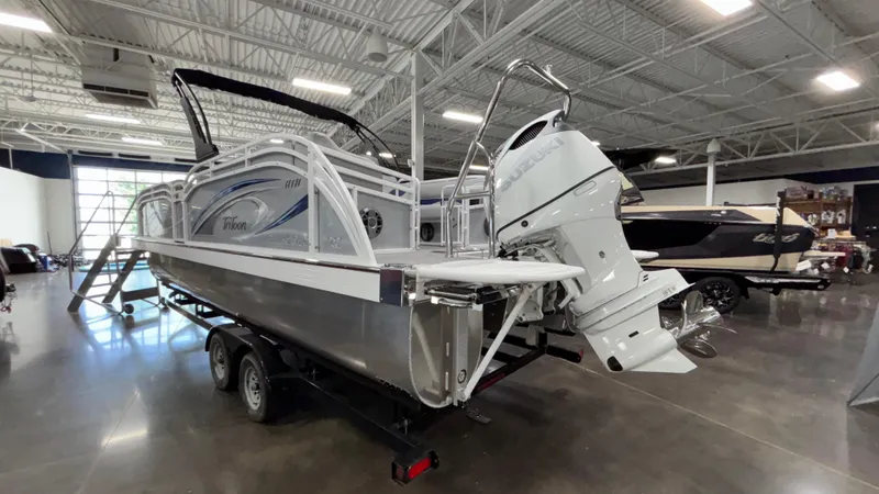 Slide: The Image of 2025 JC Neptoon 25TT Sport pontoon boat in showroom, featuring sleek design and powerful engine. - 2