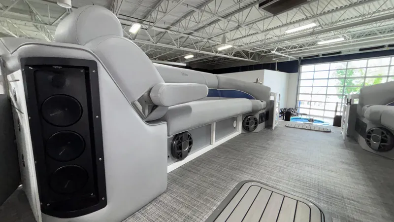 Slide: The Image of 2025 JC Neptoon 25TT Sport pontoon boat interior with gray seating and built-in speakers. - 28