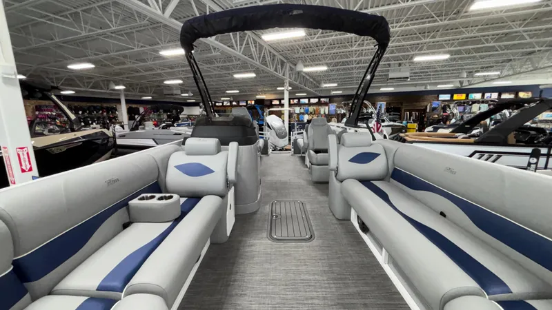 Slide: The Image of 2025 JC Neptoon 25TT Sport pontoon boat interior with gray and blue seating in showroom. - 7