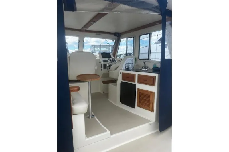 Slide: The Image of Interior of a 2016 Eastern 27 Islander boat with seating and kitchenette. - 14