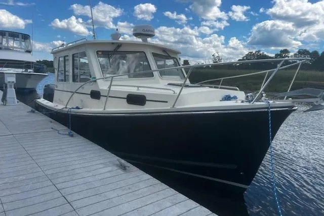 Slide: The Image of 2016 Eastern 27 Islander boat docked under a partly cloudy sky. - 3