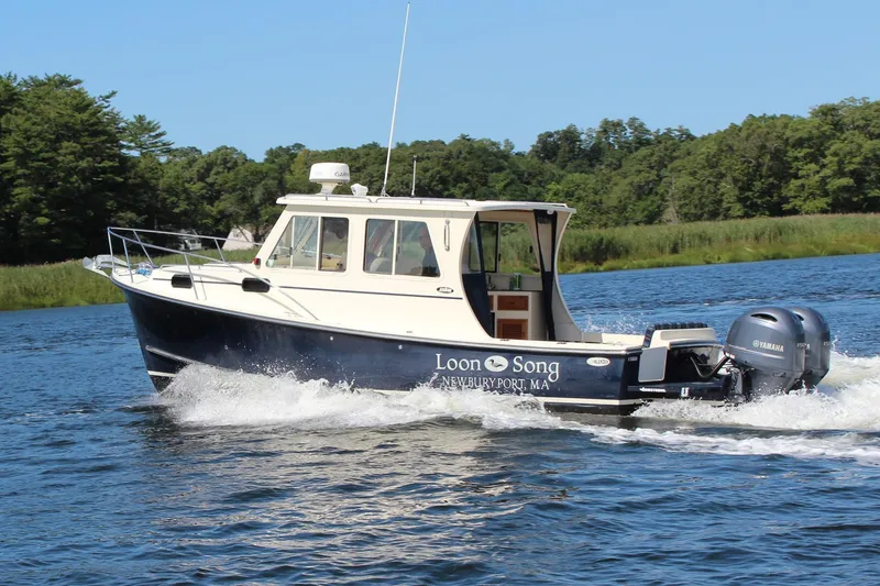 The Image of 2016 Eastern 27 Islander boat cruising on a scenic river with lush greenery. - 0