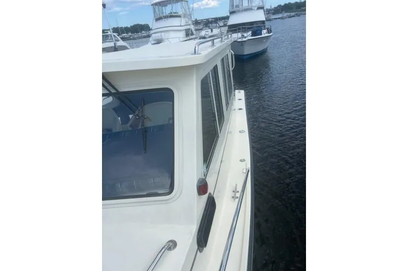 Slide: The Image of 2016 Eastern 27 Islander boat docked on calm water, side view. - 36