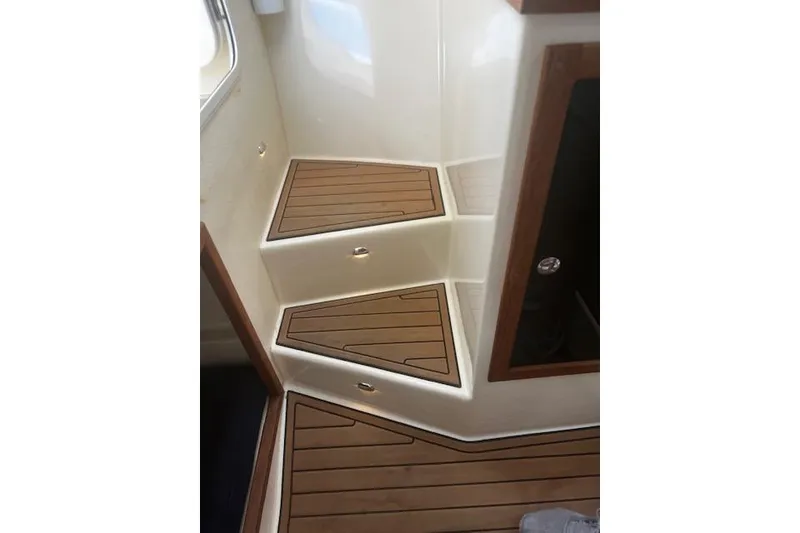 Slide: The Image of Teak steps on a 2016 Eastern 27 Islander boat interior. - 25