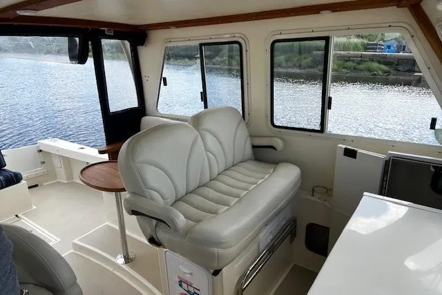 Slide: The Image of Interior of 2016 Eastern 27 Islander boat with plush seating and scenic water view. - 18
