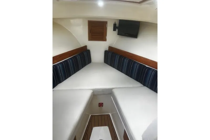 Slide: The Image of Interior of 2016 Eastern 27 Islander boat with cushioned seating and wall-mounted TV. - 27