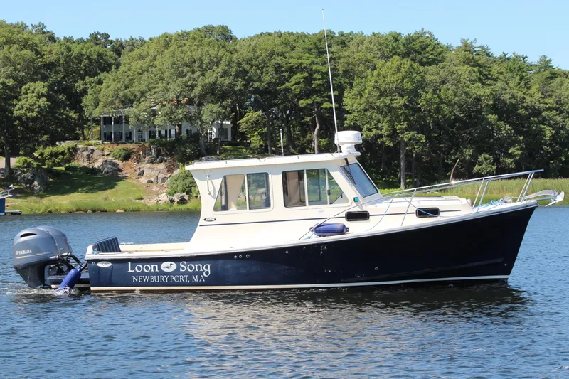 Slide: The Image of 2016 Eastern 27 Islander boat named "Loon Song" on a scenic lake. - 2