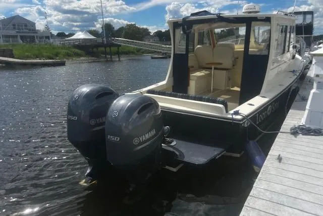 Slide: The Image of 2016 Eastern 27 Islander boat with twin Yamaha 150 engines docked by the water. - 5
