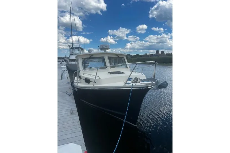 Slide: The Image of 2016 Eastern 27 Islander boat docked under a blue sky with clouds. - 4
