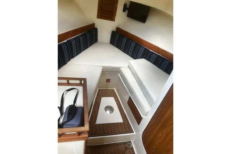 Slide: The Image of Interior of 2016 Eastern 27 Islander boat with cushioned seating and wooden accents. - 26
