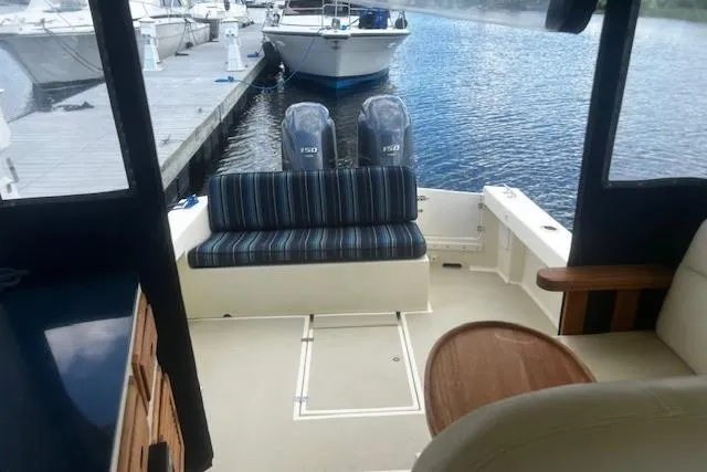 Slide: The Image of 2016 Eastern 27 Islander boat interior with striped seating and twin engines at dock. - 17