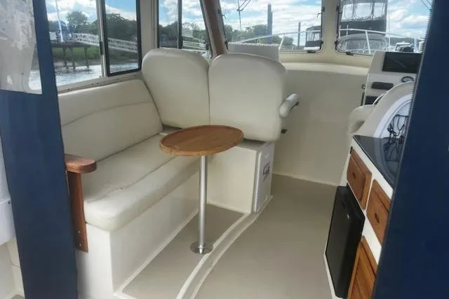 Slide: The Image of Interior of a 2016 Eastern 27 Islander boat with seating and a small table. - 16