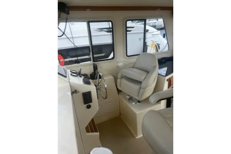 Slide: The Image of Interior of a 2016 Eastern 27 Islander boat, featuring helm and seating area. - 24