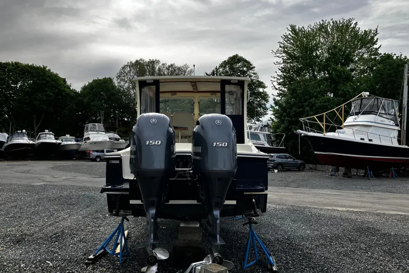 Slide: The Image of 2016 Eastern 27 Islander boat with dual Yamaha 150 engines in a marina setting. - 32