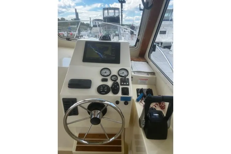 Slide: The Image of Helm of 2016 Eastern 27 Islander boat with navigation equipment and steering wheel. - 19