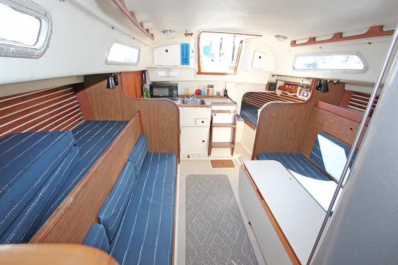 Slide: The Image of Interior of a 1977 Pearson 10M sailboat with blue seating and wooden accents. - 4