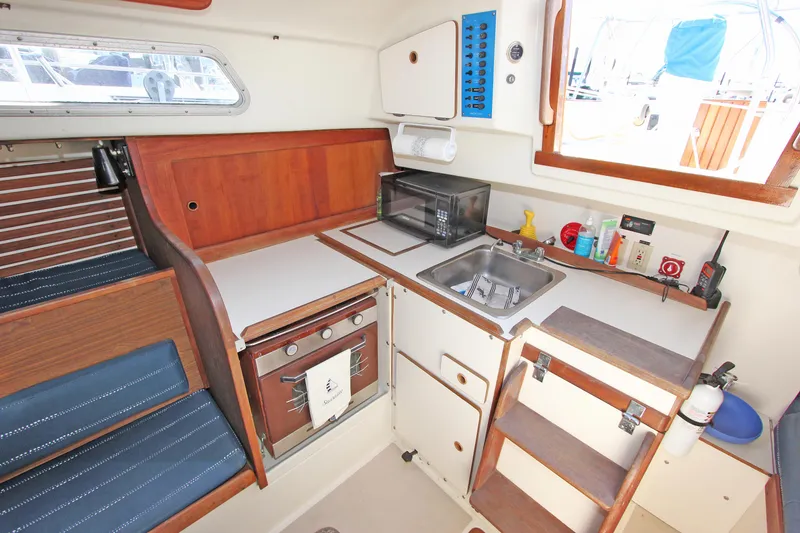 Slide: The Image of 1977 Pearson 10M sailboat galley with stove, sink, and storage cabinets. - 8