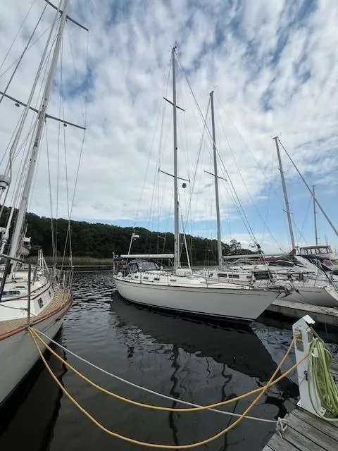 Slide: The Image of 1987 Tartan 40CB sailboat docked in a marina under a partly cloudy sky. - 10