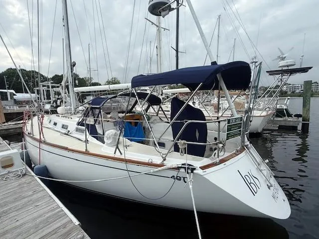 Slide: The Image of 1987 Tartan 40CB sailboat docked, featuring blue canopy and sleek design. - 13